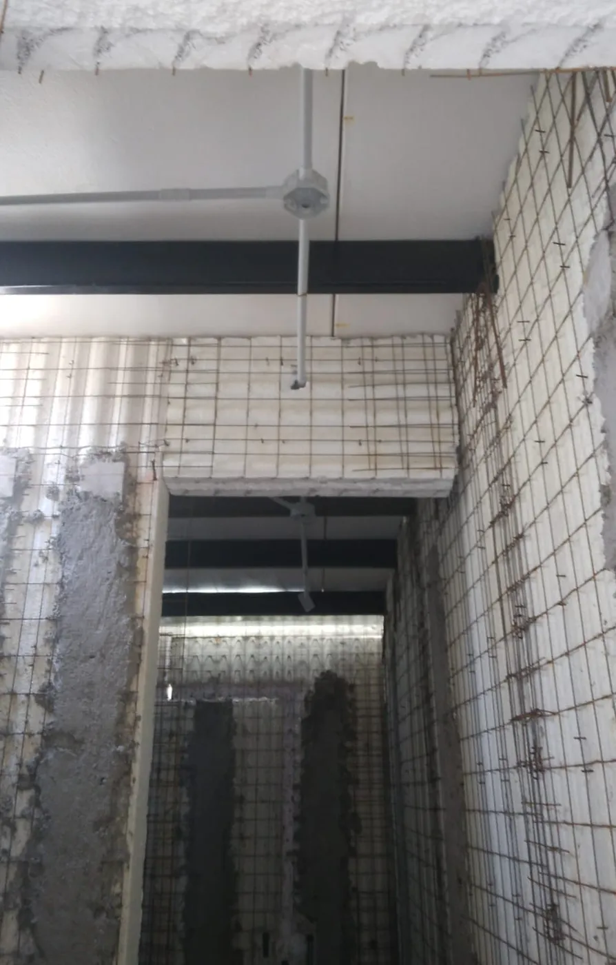 Obra en ejecución con paneles Ecowalls: núcleo de EPS, malla de acero y primeras capas de hormigón proyectado